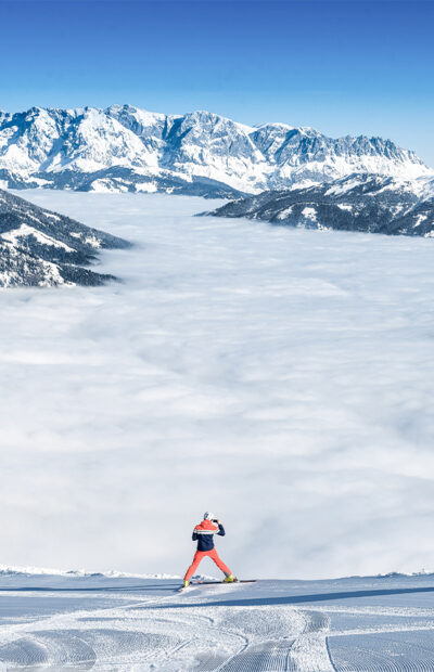 Ein Skifahrer fotografiert eine dichte Nebeldecke welche über dem Gasteinertal hängt
